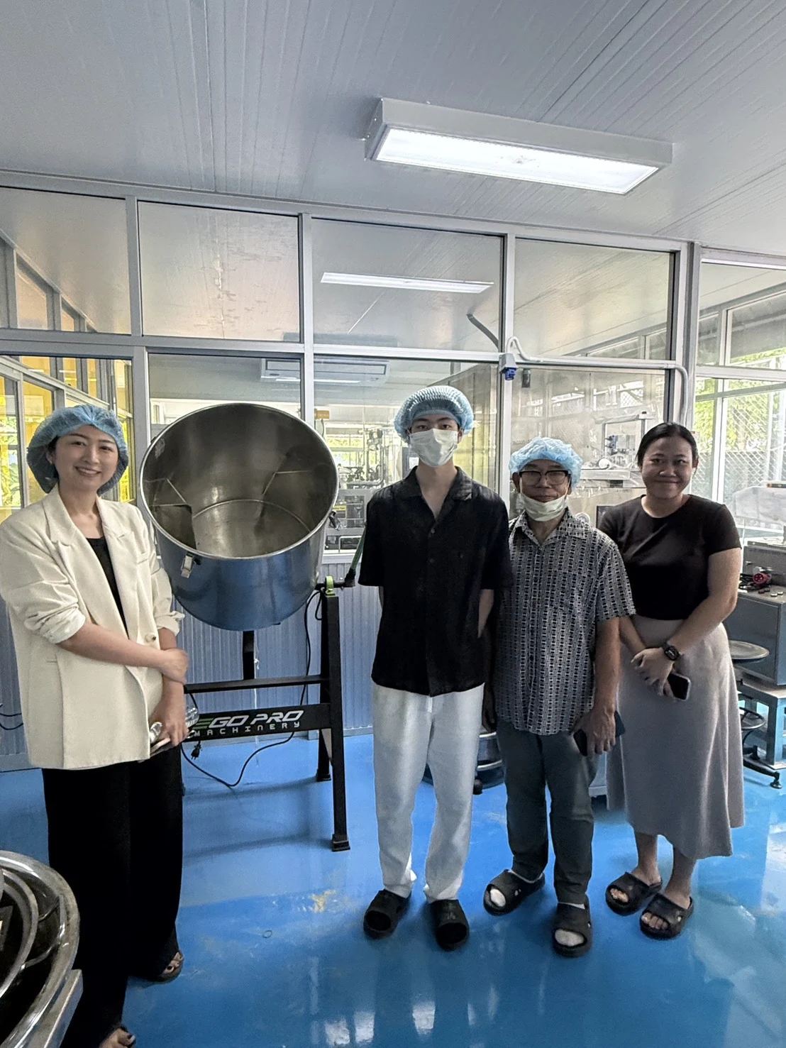The project team beside a mixing machine at the processing facility